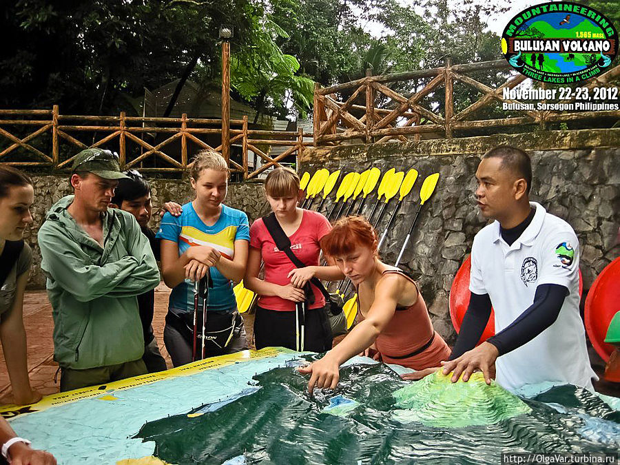 Филипп знакомит группу с программой двухдневного похода, показывая на макете  маршрут — от озера Булусан через тропический лес к стоянке на озере Агуингэй (lake Aguingay), а уже затем на вершину вулкана высотой 1565 метров Булусан, Филиппины