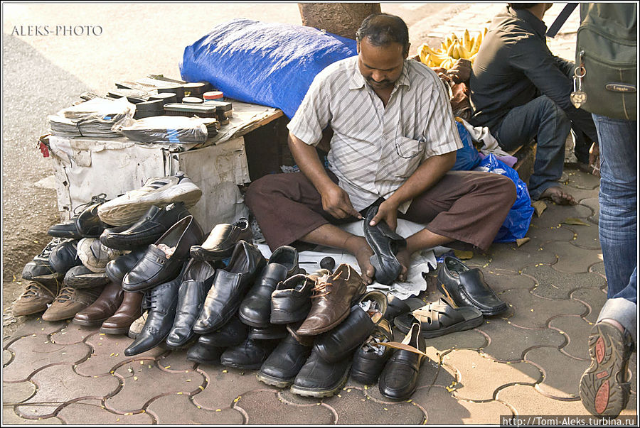 Уличный мастер по ремонту обуви. Зачем какие-то киоски — садись вот так запросто на землю под деревом и занимайся привычным и нужным делом, получая взамен честно заработанные рупии...
* Мумбаи, Индия