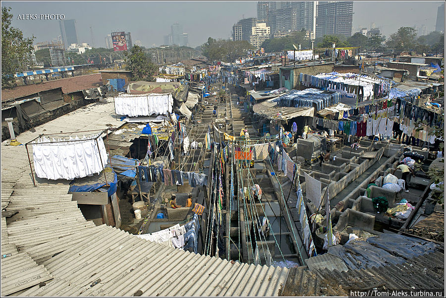 Почти вплотную к прачечной уже подошли строящиеся небоскребы, а слева за забором проходит электричка бомбейского метро...
* Мумбаи, Индия