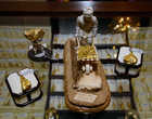 Настольная фигурка горняка, везущего тачку золотых самородков, выполненная сама из бивня мамонта и водруженная на подставку из полудрагоценного камня.