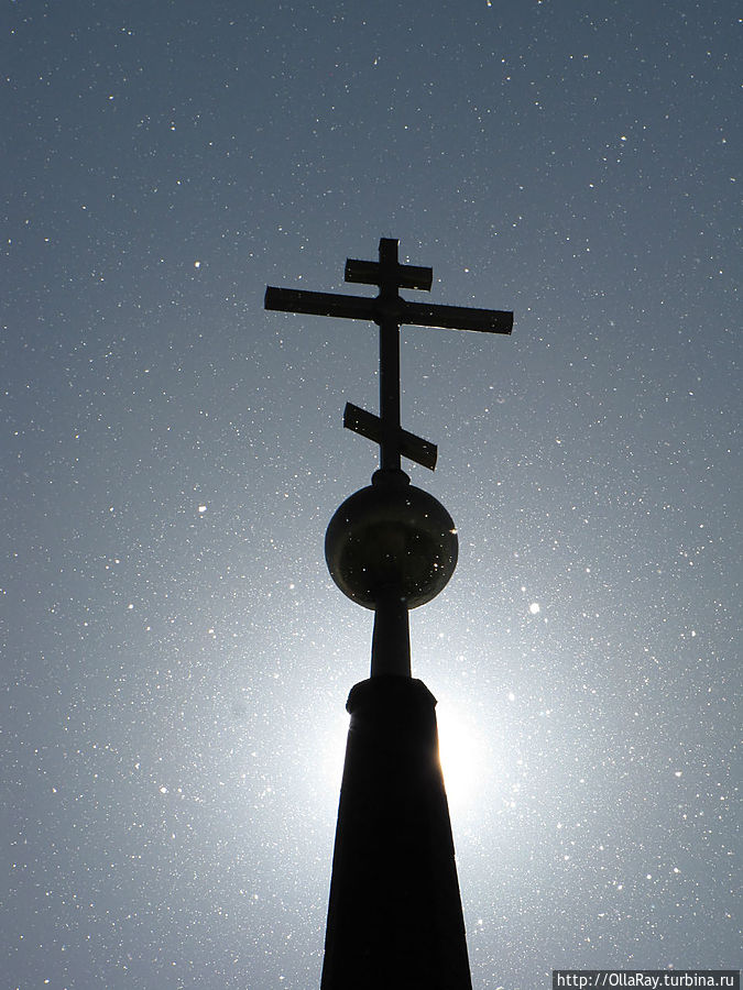 Крест колокольни Рождественской церкви в лучах солнца и в парящем тополином пухе. Череповец, Россия