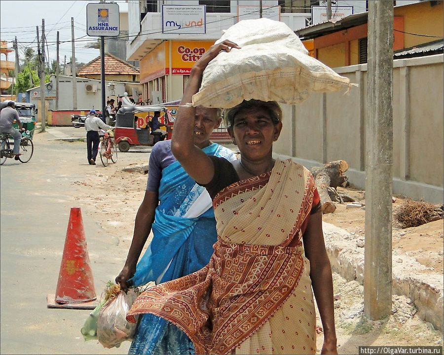 Если зонта нет, то можно водрузить на голову свою поклажу, чтобы укрыться от солнца... Тринкомали, Шри-Ланка