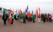 Торжественный парад открывают волонтеры с флагами всех государств, спортсмены которых будут участвовать в этих Играх