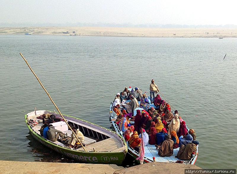 Паломники собираются плыть на правый, пустынный берег Ганги Варанаси, Индия