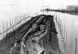 Общий вид дамбы с временными укреплениями ведущей к Саратовскому железнодорожному мосту 
(во время строительства моста). Фото из фондов музея Приволжской железной дороги
