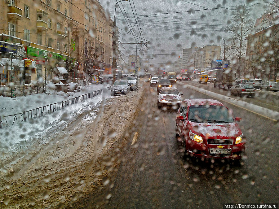 теплый троллейбус растапливает снег на стекле, демонстрируя красивые импрессионистские картины снежно-серого города Москва, Россия
