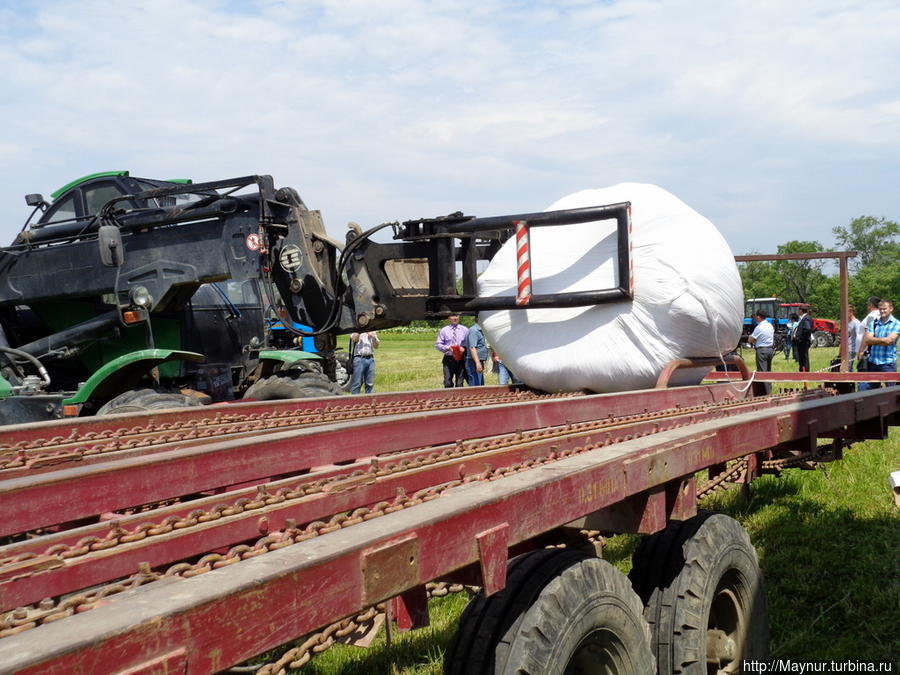 Погрузчик укладывает его на платформу прицепа, который вмещает до 14 таких рулонов. Южно-Сахалинск, Россия Погрузчик укладывает его на платформу прицепа, который вмещает до 14 таких рулонов. Южно-Сахалинск, Россия