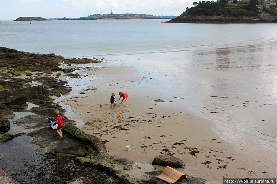 Детишки месят мокрый песок босыми ножками. Динар, Франция