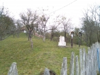 Надгробие и два креста в саду у дома