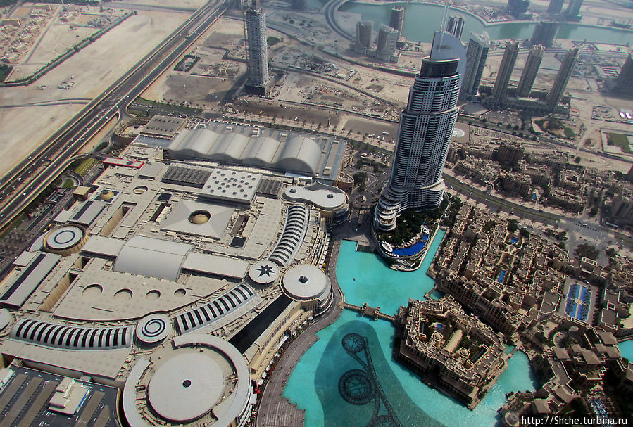 Только поднялись — выход на открытую сверху (то есть очень жарко!) застекленную плошадку. Смотрим вниз, под нами Дубаи Молл — крупный торговый центр и фонтаны Дубай, ОАЭ