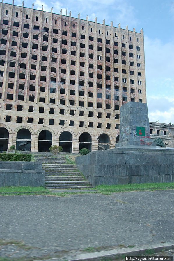 Сгоревшее здание Правительства Абхазии. На переднем плане постамент от памятника Ленину Сухум, Абхазия