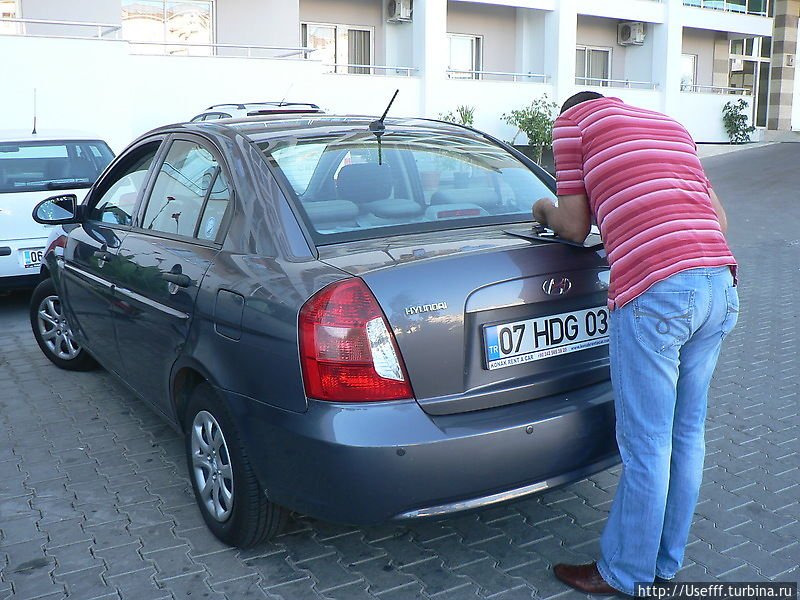 Мужик который пригнал автомобиль к отелю, заполняет договор аренды Мужик который пригнал автомобиль к отелю, заполняет договор аренды