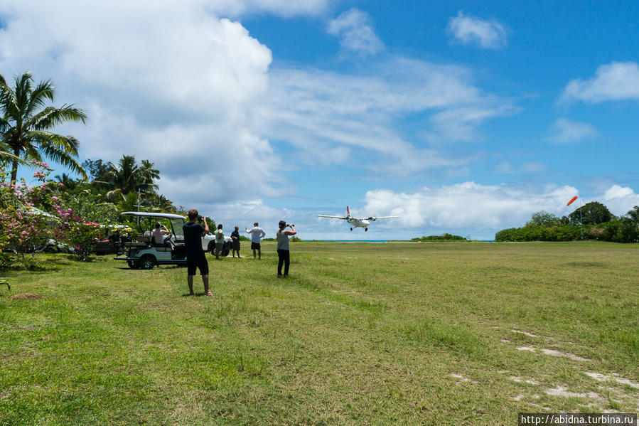 Группа отъезжающих с острова приветствует приближающийся самолетик Остров Дэнис, Сейшельские острова