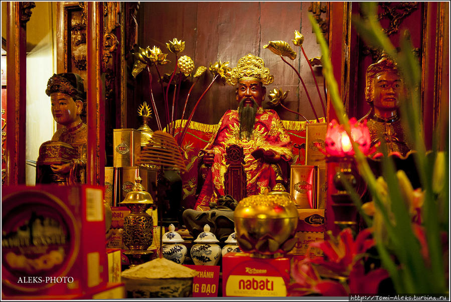 Вьетнамские божки и боги в Храме Нефритовой горы, расположенном на озере. У скульптур, изображающих сцены буддизма, всегда стоят щедрые подношения... Ханой, Вьетнам
