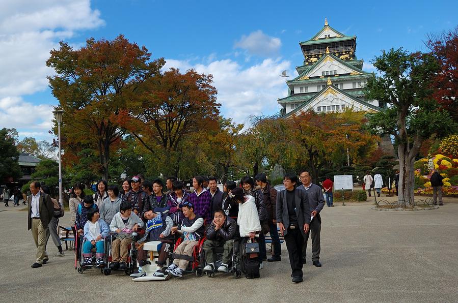 Туристы на фоне замка. Об инвалидах в Японии заботятся Осака, Япония