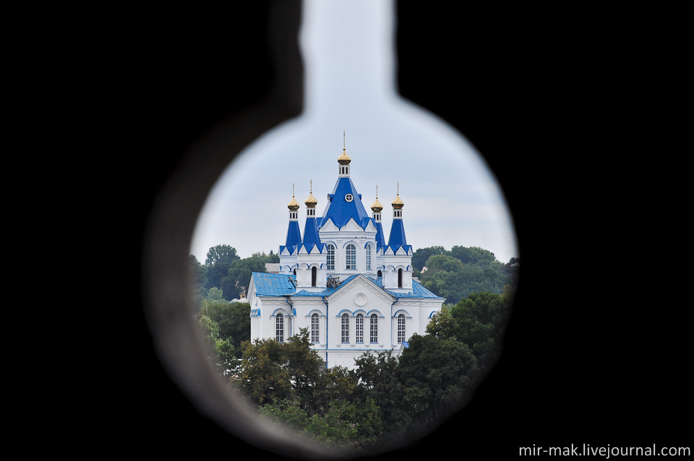 В отверстии бойницы виден Свято-Георгиевский кафедральный собор. Каменец-Подольский, Украина