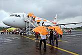 *Дождь так и не прекратился, когда самолет приземлился, и нам выдали оранжевые зонтики
