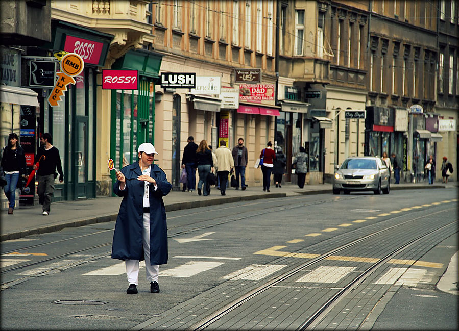 регулировщик показывает автомобилистам идет или нет трамвай Загреб, Хорватия