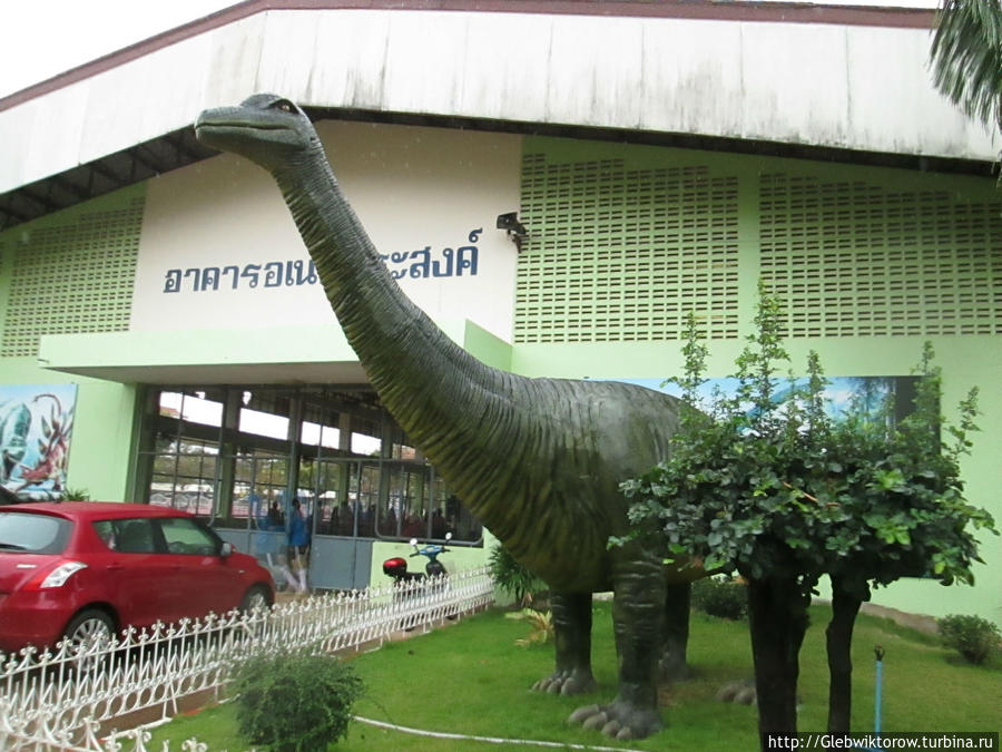 Посещение городской школы с динозавром у входа Сакон-Накхон, Таиланд