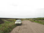 Водители продолжают путь по полевой дороге.