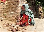 Непальская женщина должна всё уметь — расколоть тесаком маленькие брусочки...
