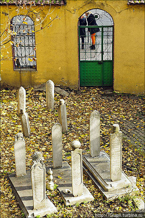 Могилы имамов. Впрочем, начитавшись разных источников, я совершенно не уверен, что это имамы. По найденной мной информации памятники женщинам легко отличить по изысканным украшениям — резным цветам, шляпкам, платкам. На крайней левой могиле как раз цветок. Над мужскими могилами верхняя часть обычно выполнена в виде головного убора — в средней могиле украшением является тюрбан, что говорит нам о том, что там похоронен человек высокого социального положения, да и крайняя справа с украшением в виде фески скорее всего принадлежит человеку не бедному.
Кладбище закрыто для посещений, но из нашего номера я частенько наблюдал, как любопытные туристы просовывают руки с фотоаппаратами через дырки в двери и фотографируют его. Могилы имамов. Впрочем, начитавшись разных источников, я совершенно не уверен, что это имамы. По найденной мной информации памятники женщинам легко отличить по изысканным украшениям — резным цветам, шляпкам, платкам. На крайней левой могиле как раз цветок. Над мужскими могилами верхняя часть обычно выполнена в виде головного убора — в средней могиле украшением является тюрбан, что говорит нам о том, что там похоронен человек высокого социального положения, да и крайняя справа с украшением в виде фески скорее всего принадлежит человеку не бедному.
Кладбище закрыто для посещений, но из нашего номера я частенько наблюдал, как любопытные туристы просовывают руки с фотоаппаратами через дырки в двери и фотографируют его.