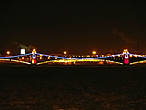 Вдали светиться огнями Троицкий мост над скованной льдом Невой