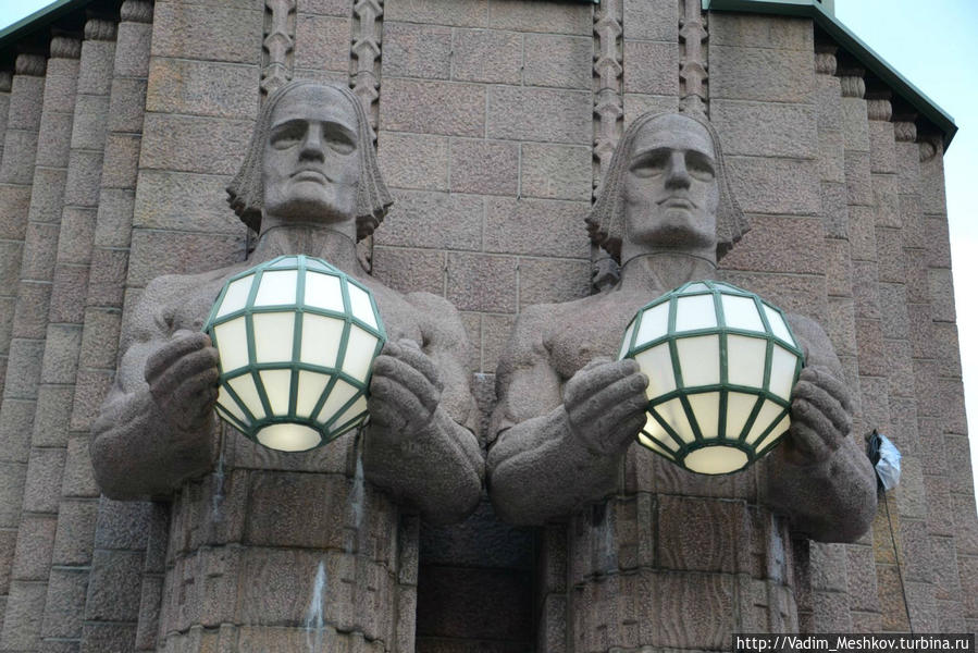 Центральный вокзал Хельсинки украшен массивными статуями атлантов с огромными светильниками в руках. Хельсинки, Финляндия