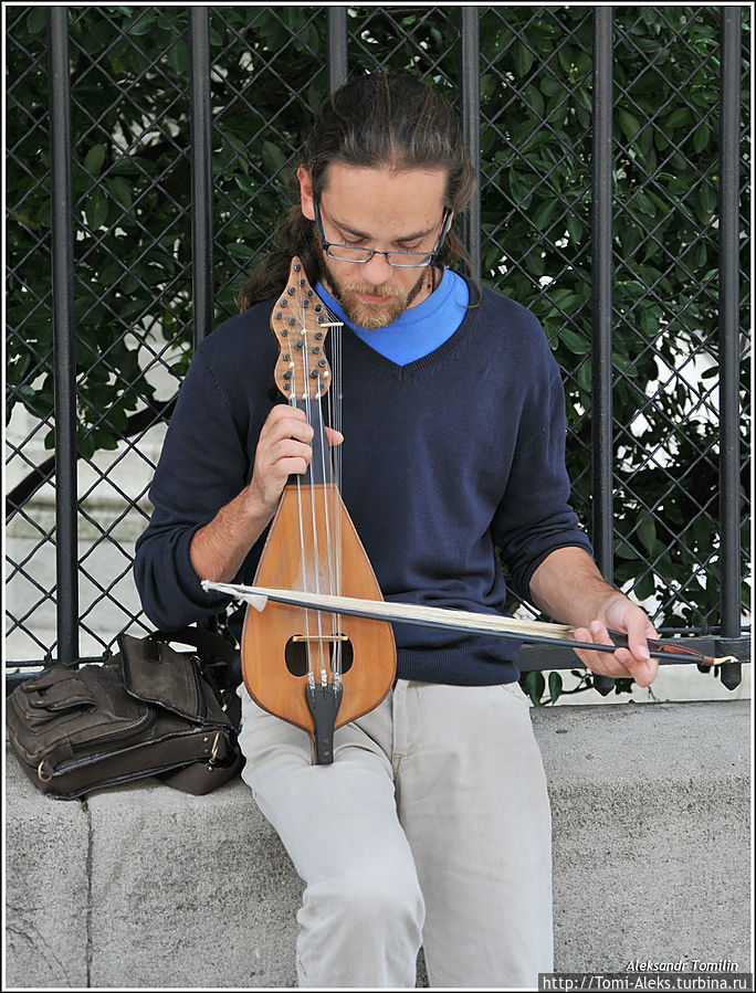 Музыкант играл на скрипке, я в глаза ему глядел. Парнишка играет у собора Нотрдам де Пари. По всей вероятности, это одна из разновидностей скрипки. Мне кажется, что-то еврейское. И как-то так жалобно он играет...
* Париж, Франция