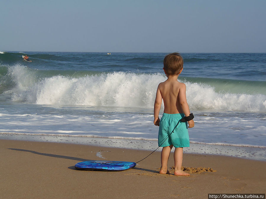 Мой маленький будущий серфингист, не может пропустить момент, чувствует всю его значимость, и спешит со своей доской на пляж. Албуфейра, Португалия