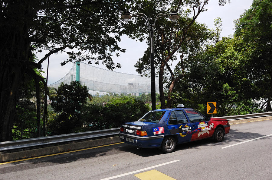 Местное такси. На заднем плане парк птиц — кусок тропического леса, накрытый сеткой Куала-Лумпур, Малайзия
