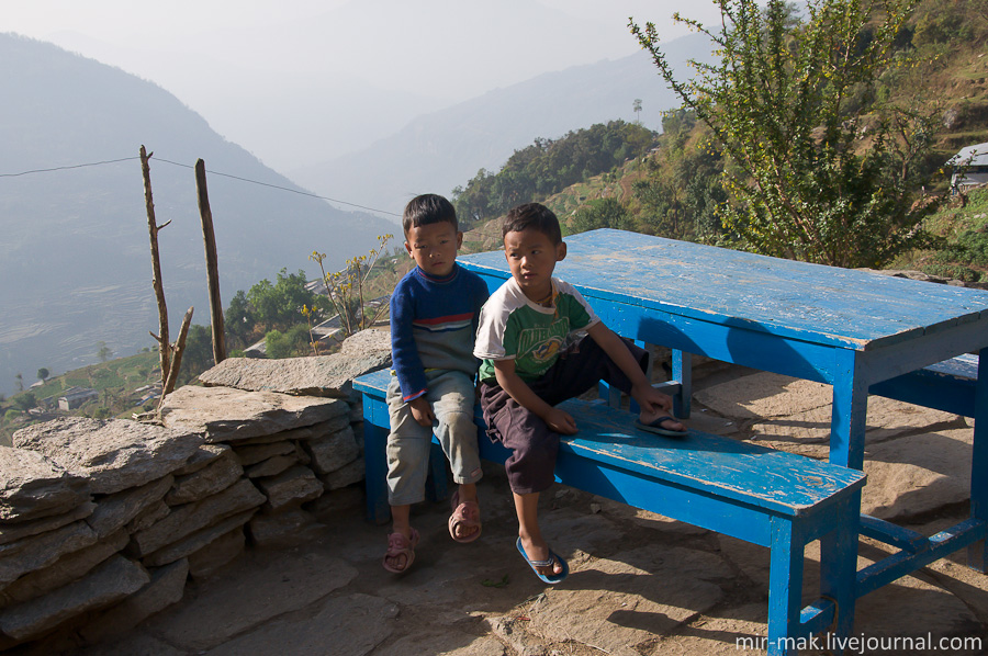 Местные дети с интересом рассматривают проходящих мимо них туристов. Непал