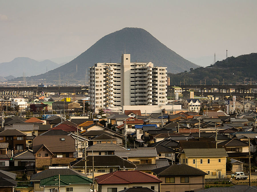 Холм-гора Сануки Фудзи, прекрасная, как боже ж ты мой, и белый мэншн на её фоне. Я не пытался снова высказаться по поводу японской урбанизации и современной архитектуры. Оно само получается, не деться от этого никуда. Это мы въехали, между тем, в Маругамэ. Префектура Кагава, Япония