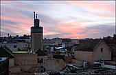Возвышающийся минарет мечети над крышами жилых домов