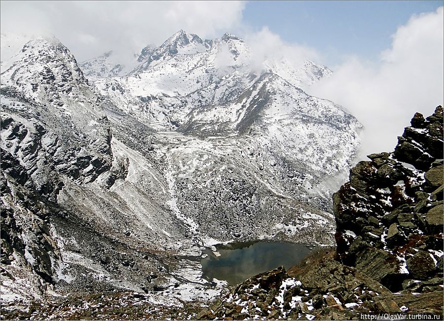 Первое маленькое озерцо, которое я увидела, пряталось сперва за облаком, а, когда то улетело, открыв обзор, оказалось, что водоем скрывал огромный камень скалы. Но и этого было достаточно, чтобы открыть рот в изумлении: озеро в заснеженных горах я видела впервые... Госайкунд, Непал