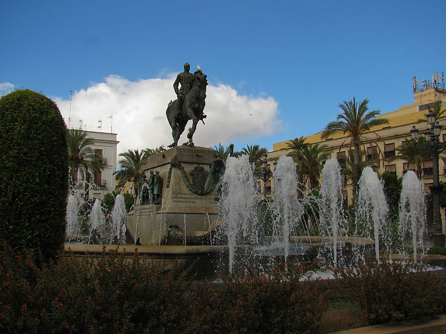 В центре площади среди фонтанов возвышается конная статуя Мигеля Примо де Ривьера (Miguel Primo de Rivera), родившегося в Хересе испанского диктатора с 1923 по 1930 год.
Однако, теперь годы его правления по сравнению с диктатурой Франко, кажутся мягкими и прогрессивными. В центре площади среди фонтанов возвышается конная статуя Мигеля Примо де Ривьера (Miguel Primo de Rivera), родившегося в Хересе испанского диктатора с 1923 по 1930 год.
Однако, теперь годы его правления по сравнению с диктатурой Франко, кажутся мягкими и прогрессивными.
