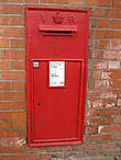 Традиционный английский почтовый ящик, встроенный в дом, чтобы не мешать движению на оживленной улице