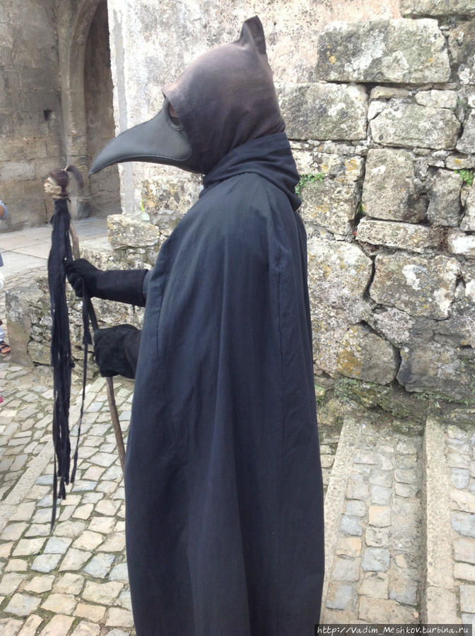 Житель Обидуша в противочумной маске встречает туристов. Обидуш, Португалия