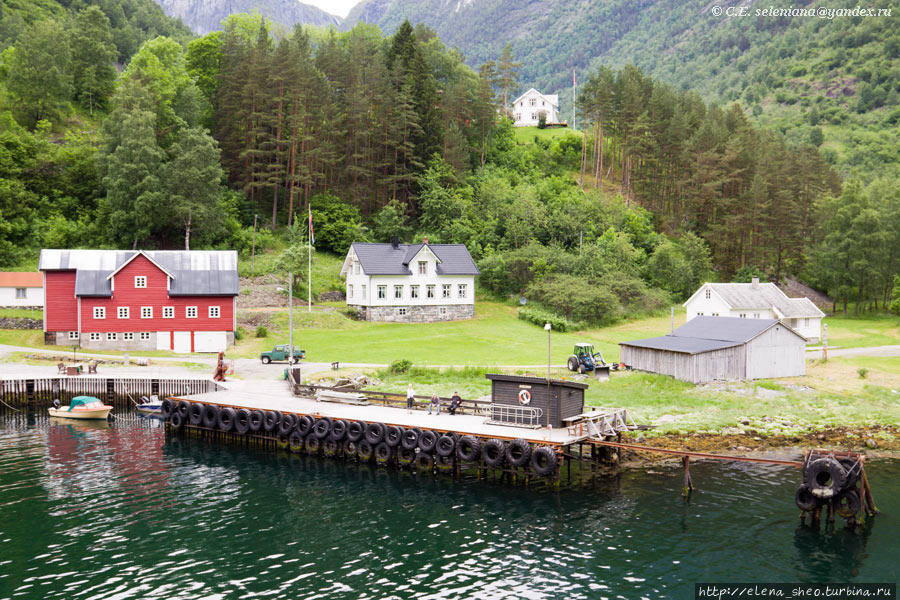 15. Живописное местечко, и дома расположены кому как захотелось. У дома на возвышении поднят норвежский флаг. Неройфьорд, Норвегия