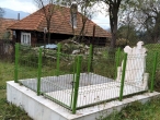 Могила с оградой у дома