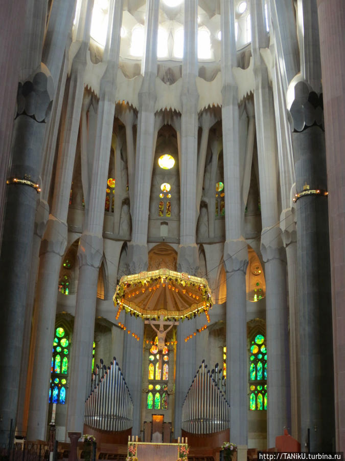 Распятие как внутри, так и над входом в храм изображает Христа в очень необычной манере. Барселона, Испания
