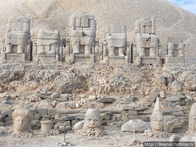 Пять огромных статуй занимают верхний уступ у основания насыпи. Это барельефы царя и его идолов. Газиантеп, Турция