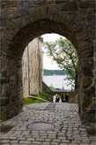15. Выйдя из замка, я пошла вдоль западного крыла по этой мощённой булыжником дороге, идущей вниз. Собственно говоря, вариантов куда идти у меня было не так уж много, а дорога поманила видом через эту арку. Интересно, что там впереди?
