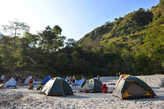 Лагерь на пещанном пляже во время рафтинга.