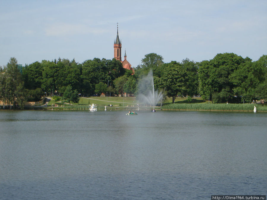 Фонтан на озере,  за озером Костёл Пресвятой Девы Марии Шкаплерной Друскининкай, Литва