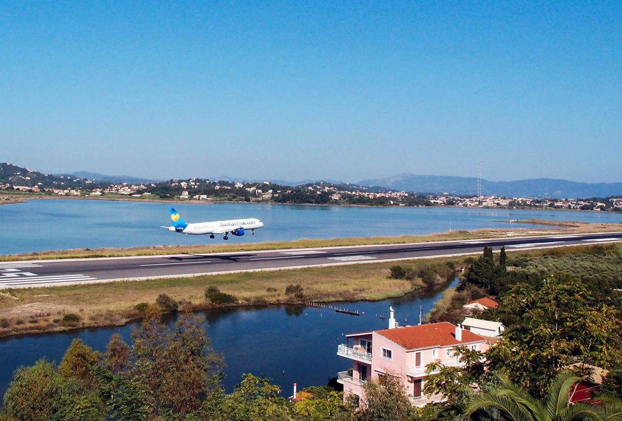 Самолет летит в Канóни Канони, остров Корфу, Греция