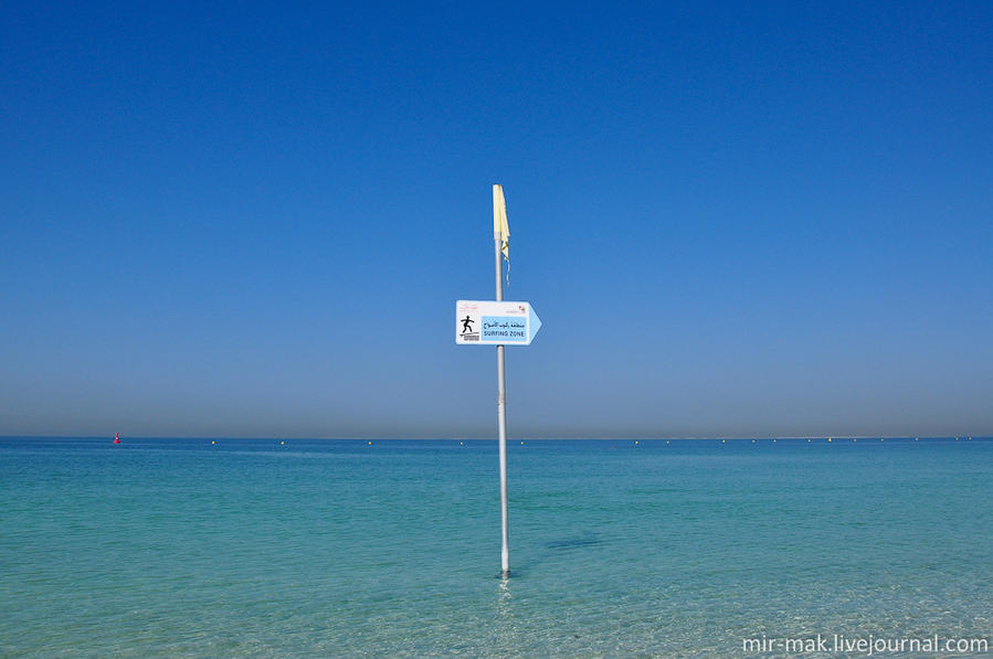 На воде штиль, поэтому табличка с надписью «зона для серфинга» смотрится несерьезно. Дубай, ОАЭ