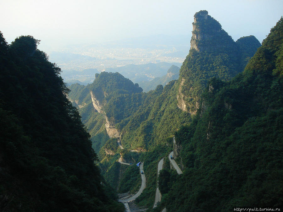 Вид на город Чжанцзяцзе и серпантин Тунтянь (Небесное шоссе) с горы Тяньмэнь (Небесные Врата) Чжанцзяцзе Национальный Лесной Парк (Парк Аватар), Китай