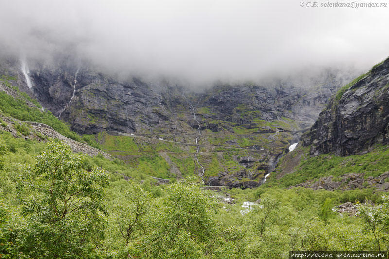 7. На склоне этой крутой горы и проложена Дорога Троллей. У неё 11 колен с крутыми поворотами, каждое из колен имеет своё название. С нашей площадки можно увидеть только ее нижние колена, верхние закрыты облаками, низко висящими над горой. Тролльстиген, Норвегия