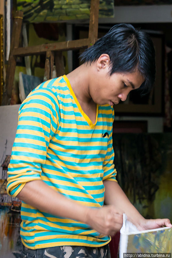 Художник, заворачивает свою картину покупателю Художник, заворачивает свою картину покупателю